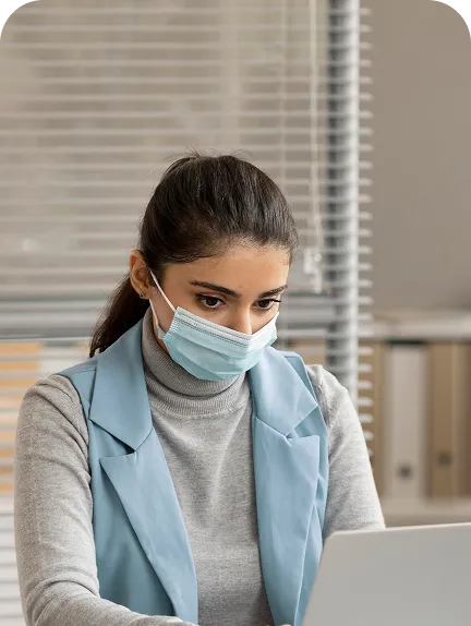 Nurse working with laptop while wearing mask